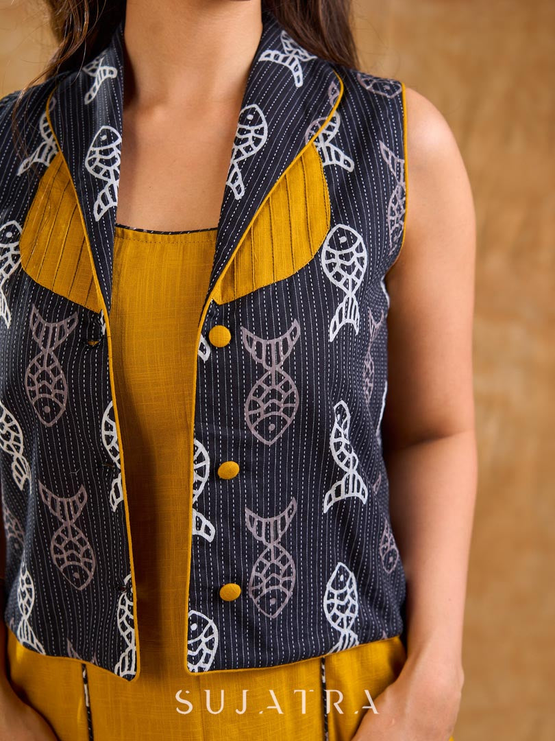 Tailored black Kantha jacket featuring fish motifs, a mustard pintuck patch, and a flipped collar, offering a structured silhouette with refined detail and distinctive, contemporary character.