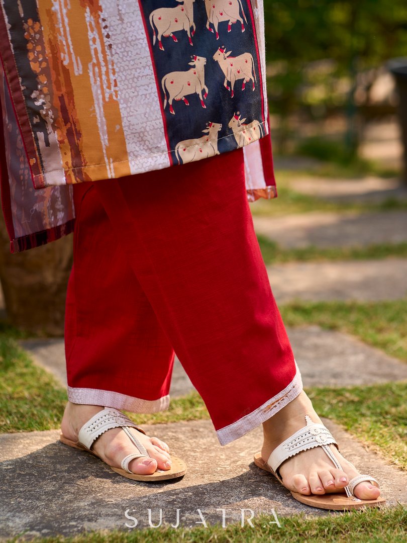 Artisanal off-white kurta showcasing Pichwai-inspired cow artwork highlighted with classic red tones