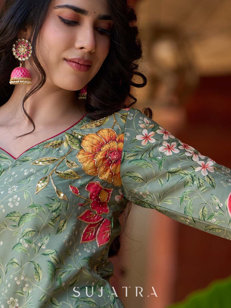 Soft green printed kurta with vibrant floral motifs, highlighted with hand embroidery and bright magenta accents.