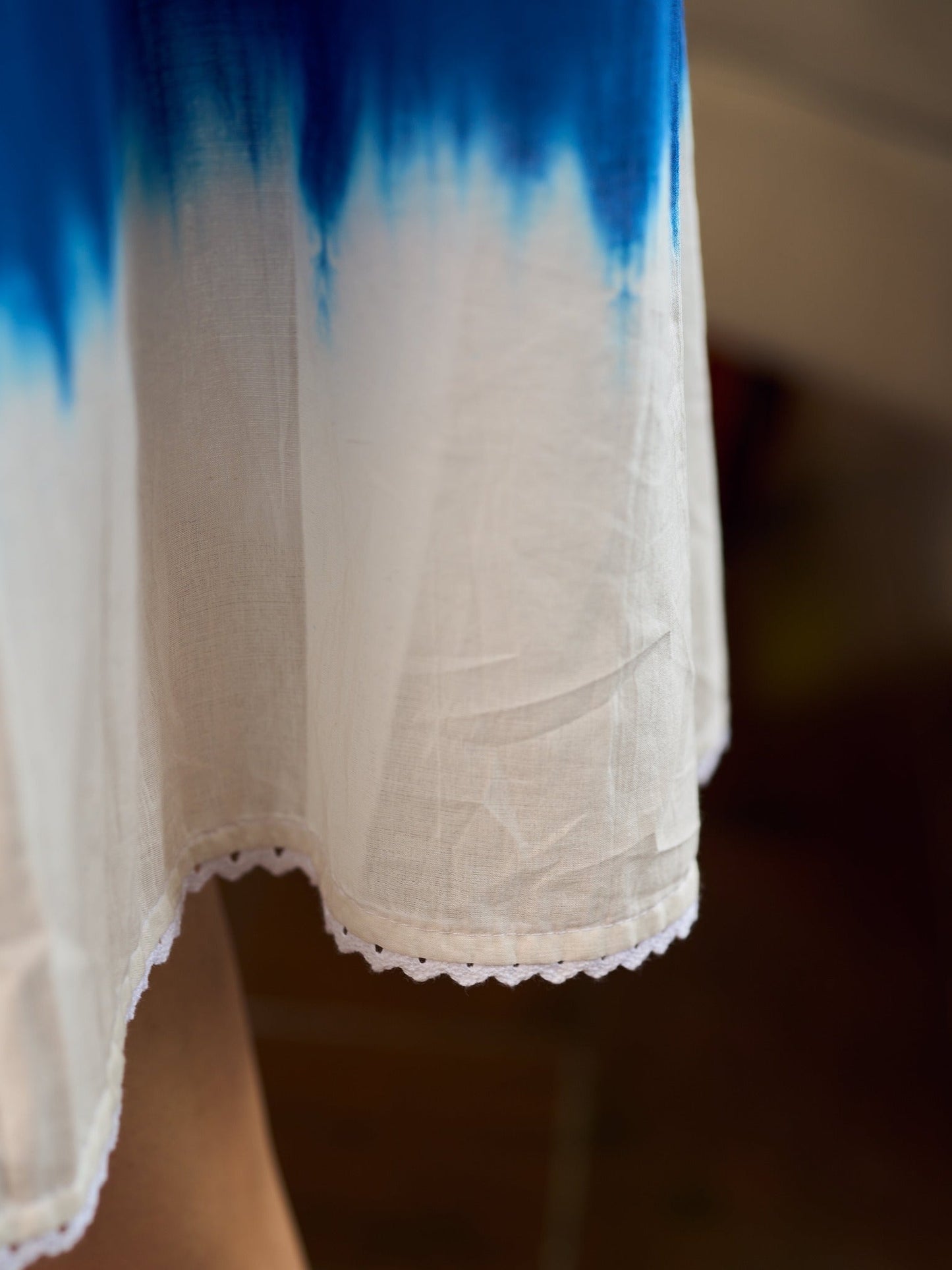Refreshing cobalt blue shibori tie-dye dress with ivory accents and delicate lace-trimmed neckline.
