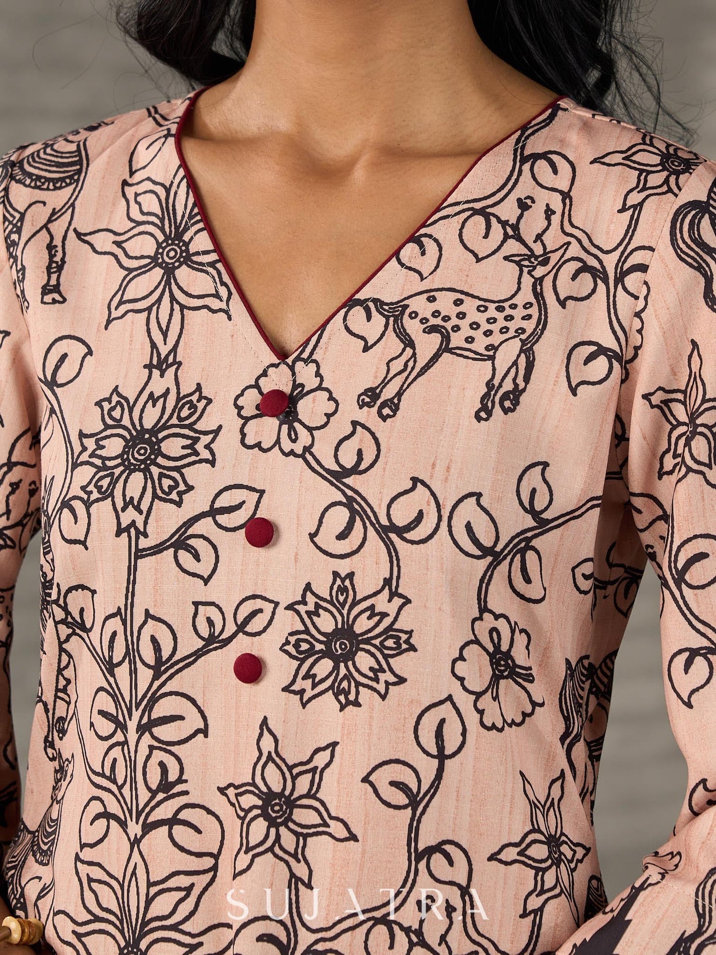 Beige traditional printed dress with rich maroon accents.