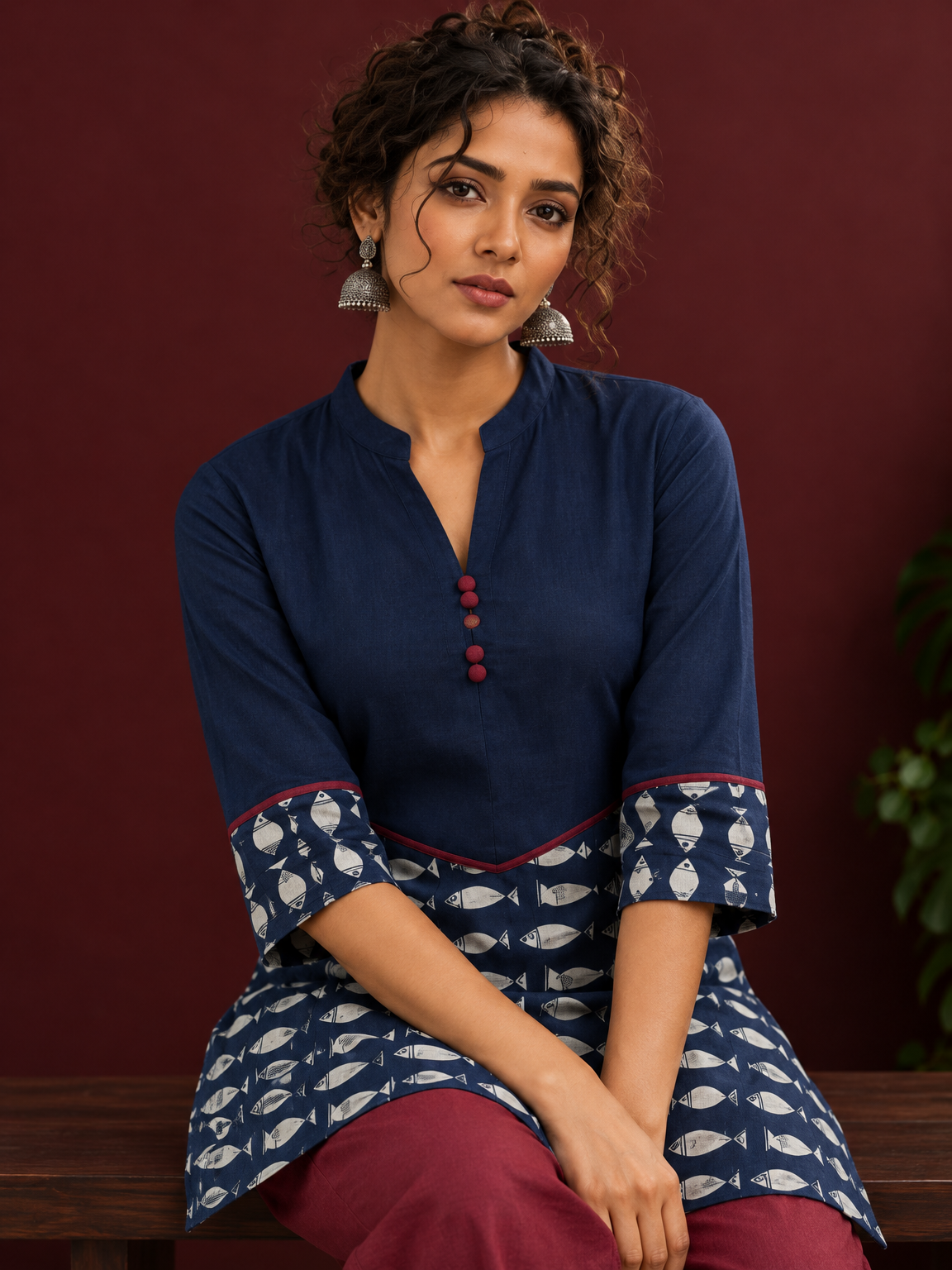 Navy Blue Cotton Tunic with Fish Print Hem Panel, Contrast Maroon Piping & Red Button Detail — seated detail