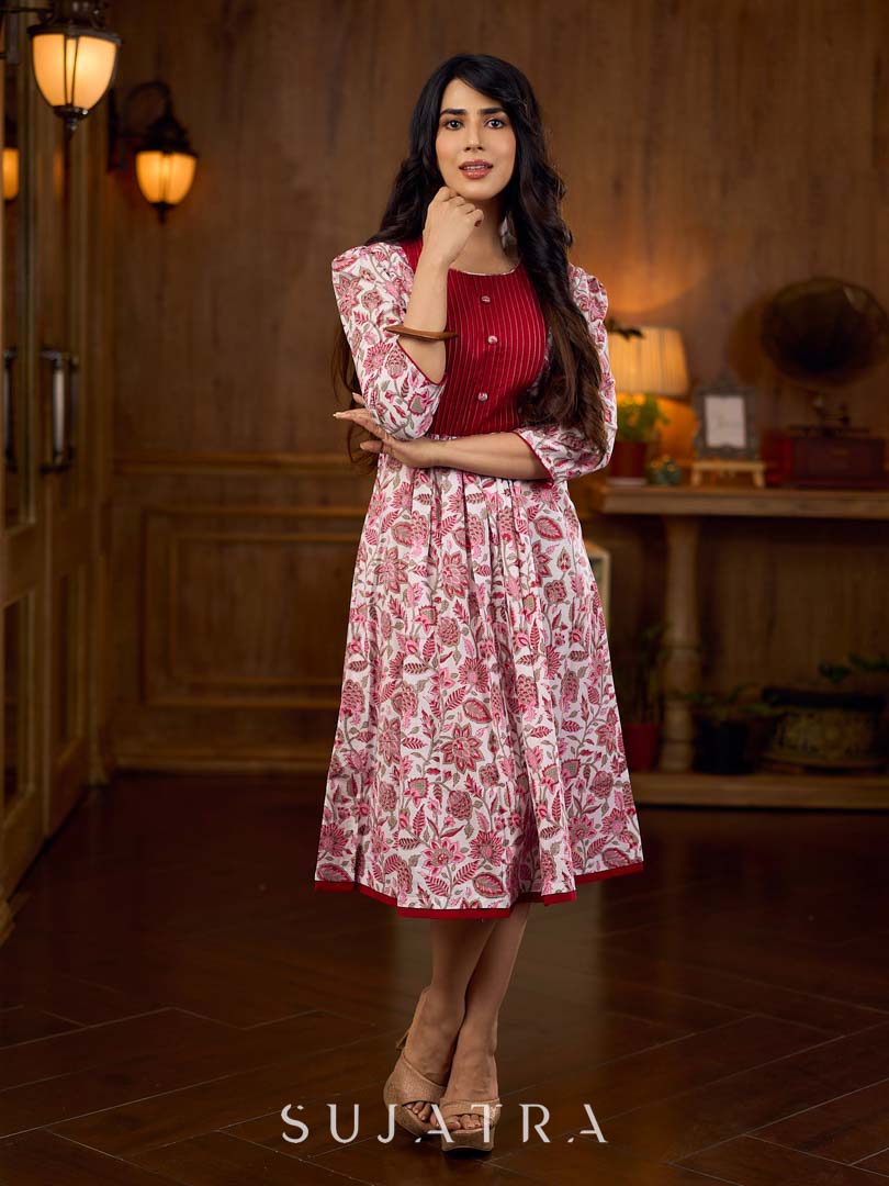 Elegant white floral Jaipuri printed dress with a delicately pintucked red panel, gathered sleeves, and rich red accents.