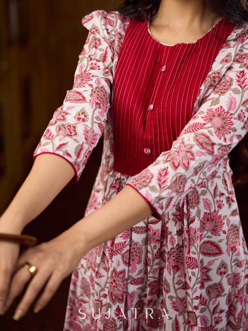 Elegant white floral Jaipuri printed dress with a delicately pintucked red panel, gathered sleeves, and rich red accents.