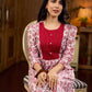 Elegant white floral Jaipuri printed dress with a delicately pintucked red panel, gathered sleeves, and rich red accents.