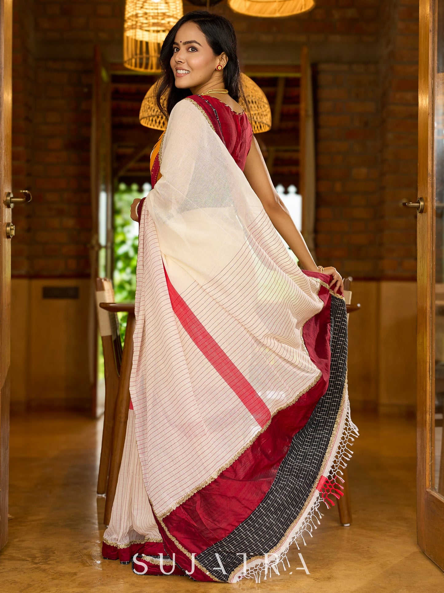 Striking white cotton saree with bold red-black borders, featuring a hand-painted Durga motif