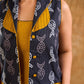 Tailored black Kantha jacket featuring fish motifs, a mustard pintuck patch, and a flipped collar, offering a structured silhouette with refined detail and distinctive, contemporary character.