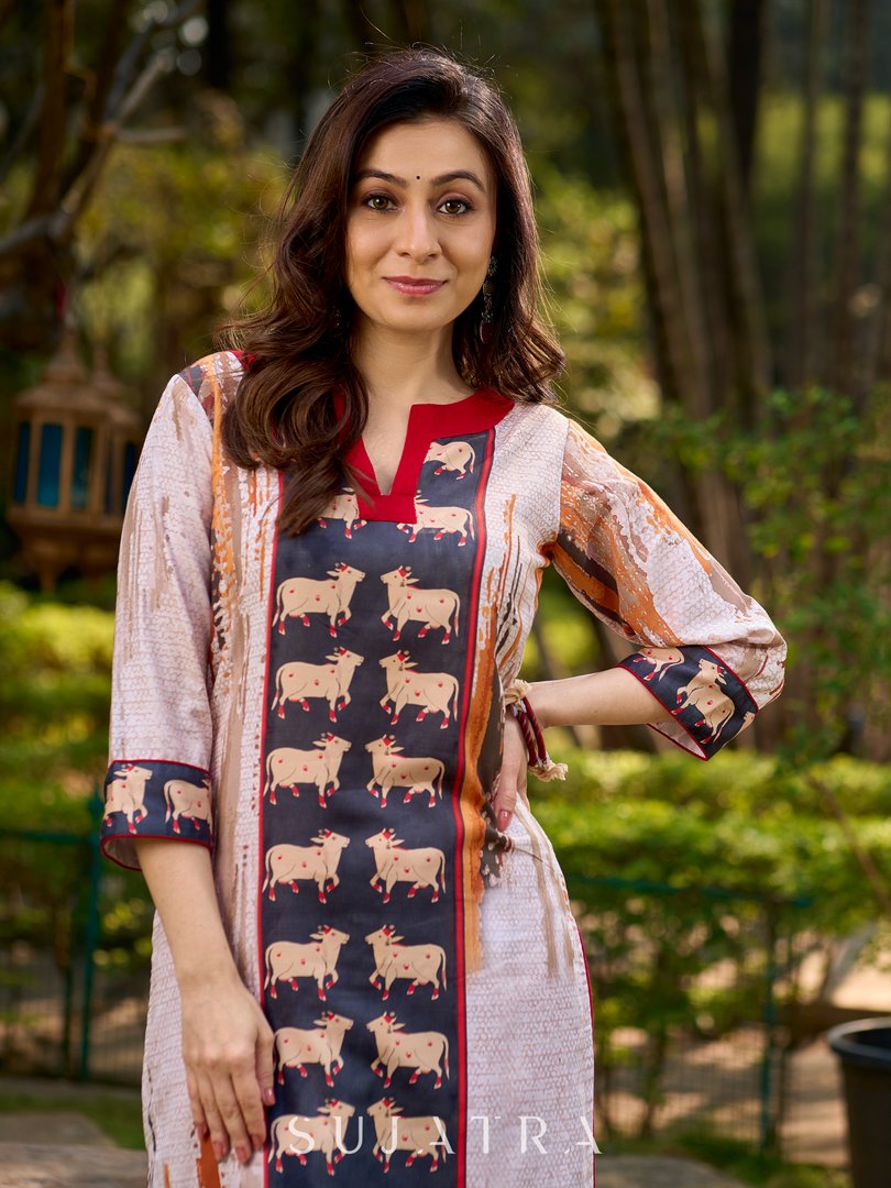 Artisanal off-white kurta showcasing Pichwai-inspired cow artwork highlighted with classic red tones