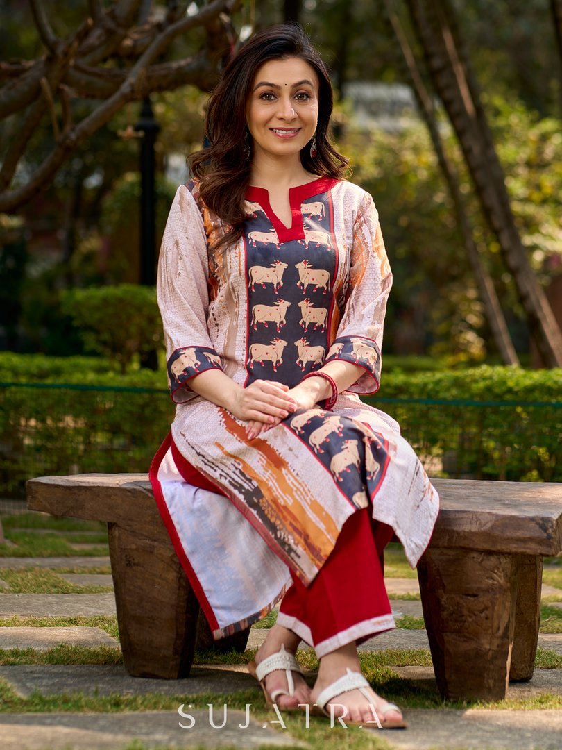 Artisanal off-white kurta showcasing Pichwai-inspired cow artwork highlighted with classic red tones