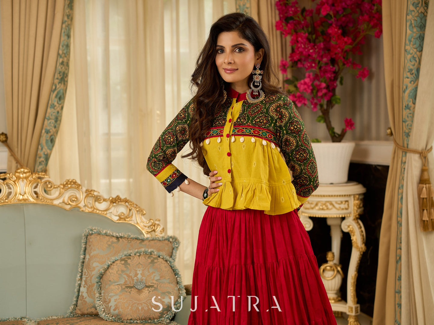Red tiered Jamdani lehenga with a striking green Ajrakh and mustard jamdani choli featuring intricate mirror work & shell tassels .