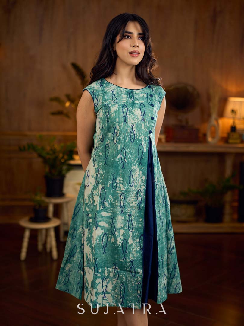 Indigo printed dress featuring playful fish motifs, designed in a gathered side-panel silhouette with contrast navy blue accents, creating a fluid, contemporary look with refined artisanal charm.