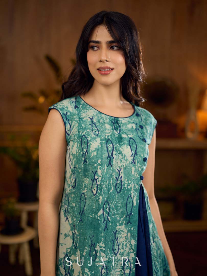 Indigo printed dress featuring playful fish motifs, designed in a gathered side-panel silhouette with contrast navy blue accents, creating a fluid, contemporary look with refined artisanal charm.