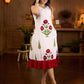 White sleeveless dress featuring red butta motifs and a gathered red panel at the hem, finished with coordinated red accents for a fresh, playful silhouette with a touch of traditional charm.