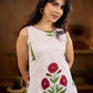 White sleeveless dress featuring red butta motifs and a gathered red panel at the hem, finished with coordinated red accents for a fresh, playful silhouette with a touch of traditional charm.