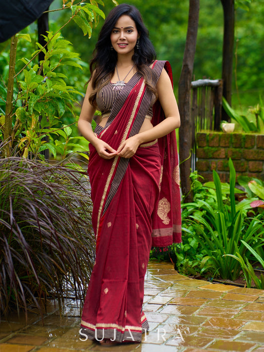 Artisanal maroon Jamdani saree elevated with zari-bordered detailing