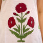White sleeveless dress featuring red butta motifs and a gathered red panel at the hem, finished with coordinated red accents for a fresh, playful silhouette with a touch of traditional charm.