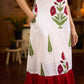 White sleeveless dress featuring red butta motifs and a gathered red panel at the hem, finished with coordinated red accents for a fresh, playful silhouette with a touch of traditional charm.