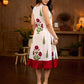 White sleeveless dress featuring red butta motifs and a gathered red panel at the hem, finished with coordinated red accents for a fresh, playful silhouette with a touch of traditional charm.