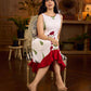 White sleeveless dress featuring red butta motifs and a gathered red panel at the hem, finished with coordinated red accents for a fresh, playful silhouette with a touch of traditional charm.