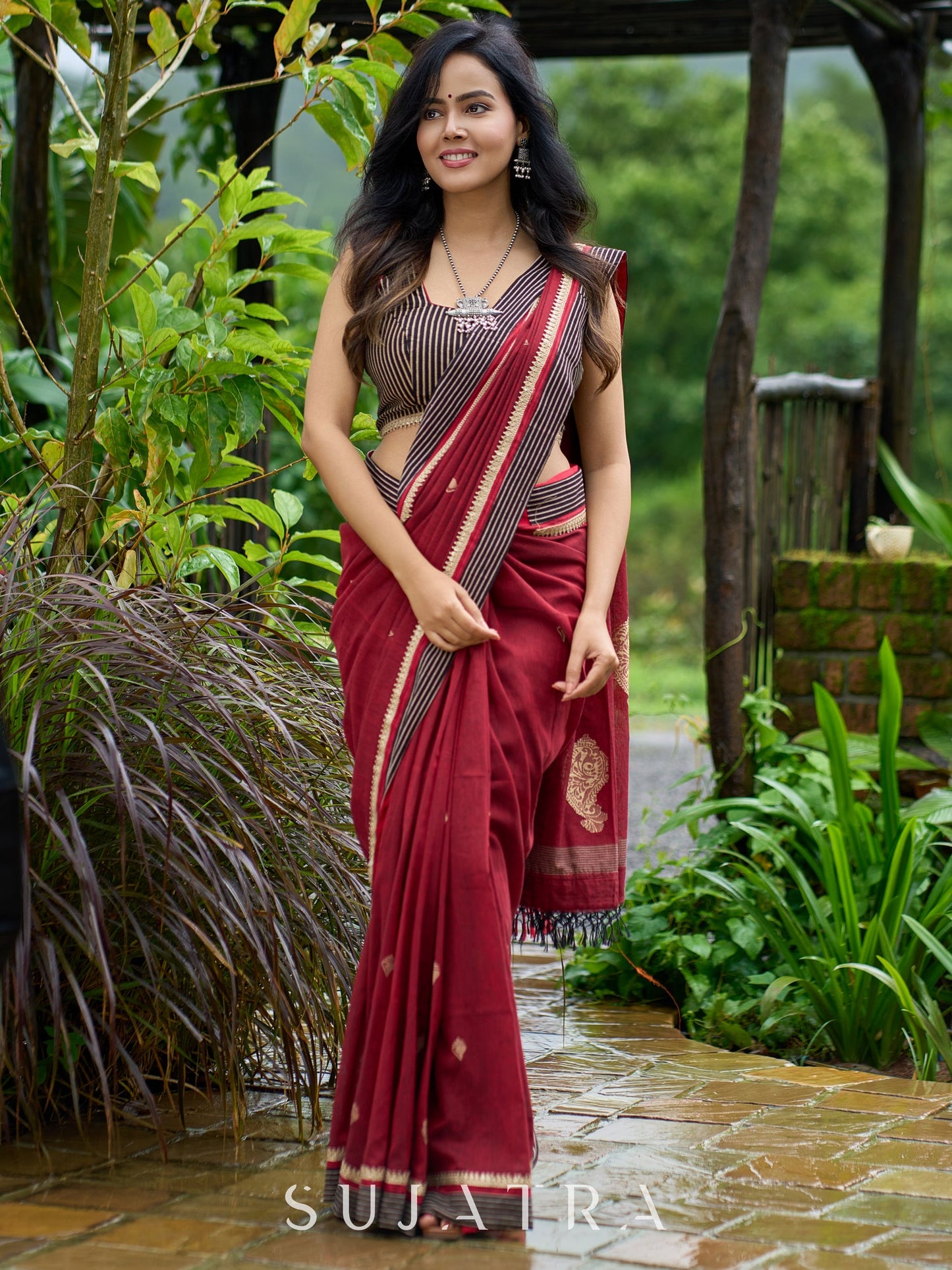 Artisanal maroon Jamdani saree elevated with zari-bordered detailing