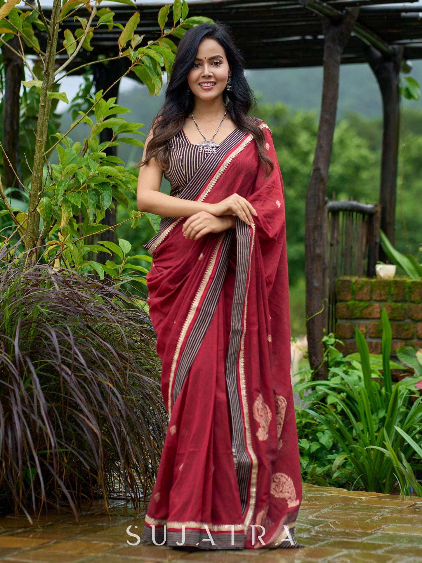 Artisanal maroon Jamdani saree elevated with zari-bordered detailing