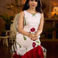 White sleeveless dress featuring red butta motifs and a gathered red panel at the hem, finished with coordinated red accents for a fresh, playful silhouette with a touch of traditional charm.