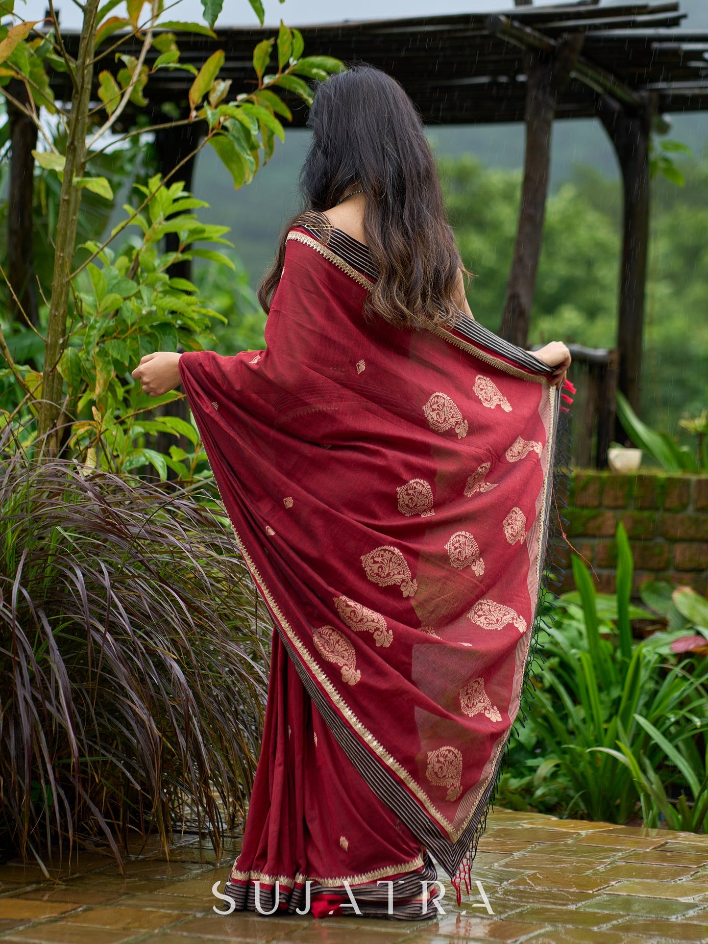 Artisanal maroon Jamdani saree elevated with zari-bordered detailing