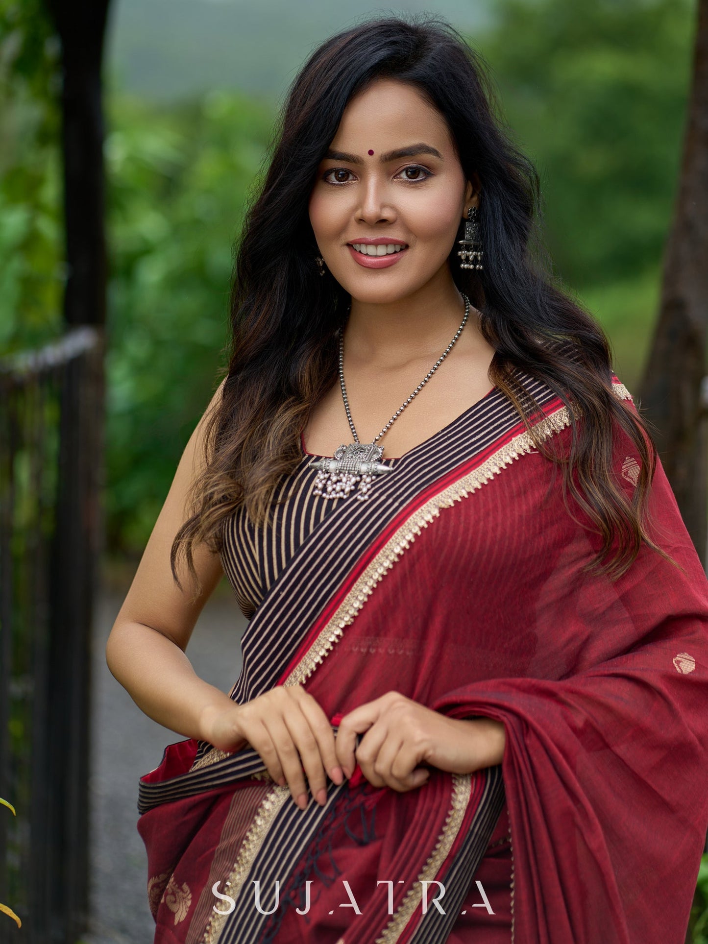 Artisanal maroon Jamdani saree elevated with zari-bordered detailing