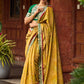 Exquisite Mustard Bandhani Print Saree with Green Benarasi Border & Tasseled Pallu with Hand Embroidered Mirror Work