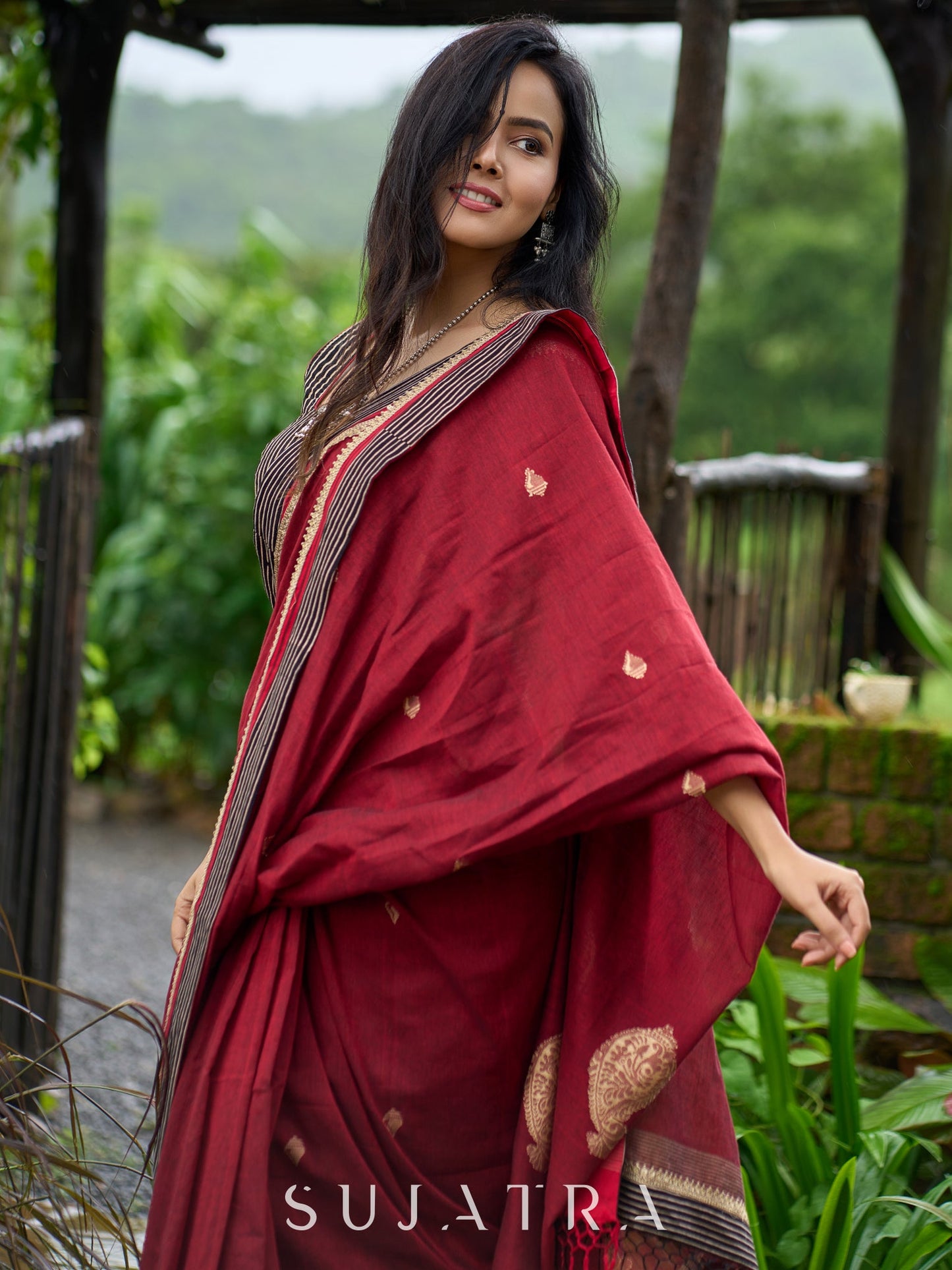 Artisanal maroon Jamdani saree elevated with zari-bordered detailing