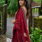 Artisanal maroon Jamdani saree elevated with zari-bordered detailing