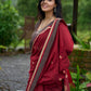Artisanal maroon Jamdani saree elevated with zari-bordered detailing