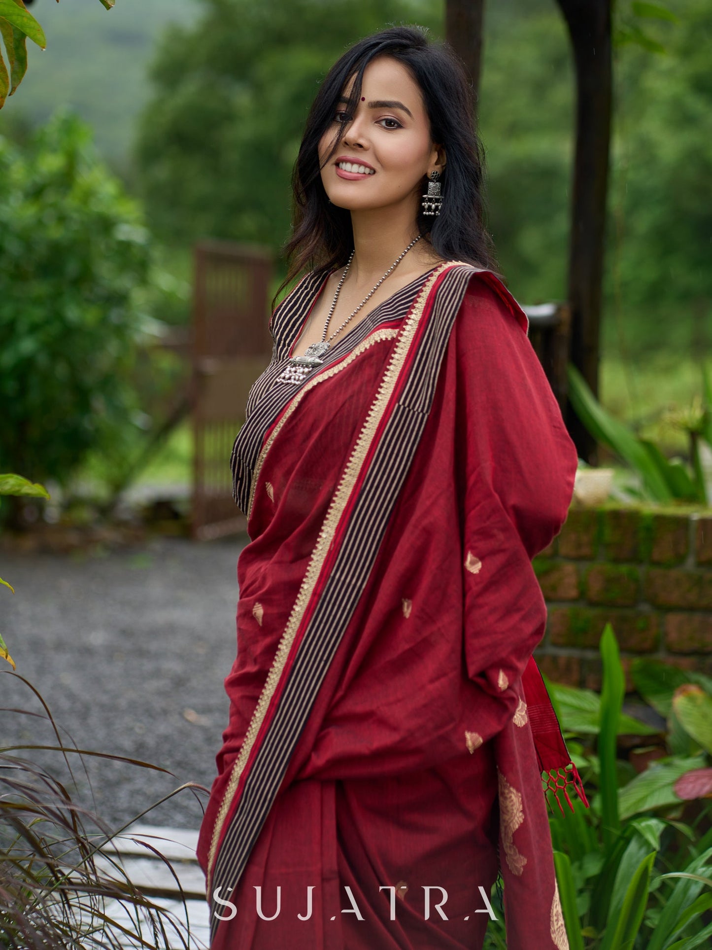 Artisanal maroon Jamdani saree elevated with zari-bordered detailing