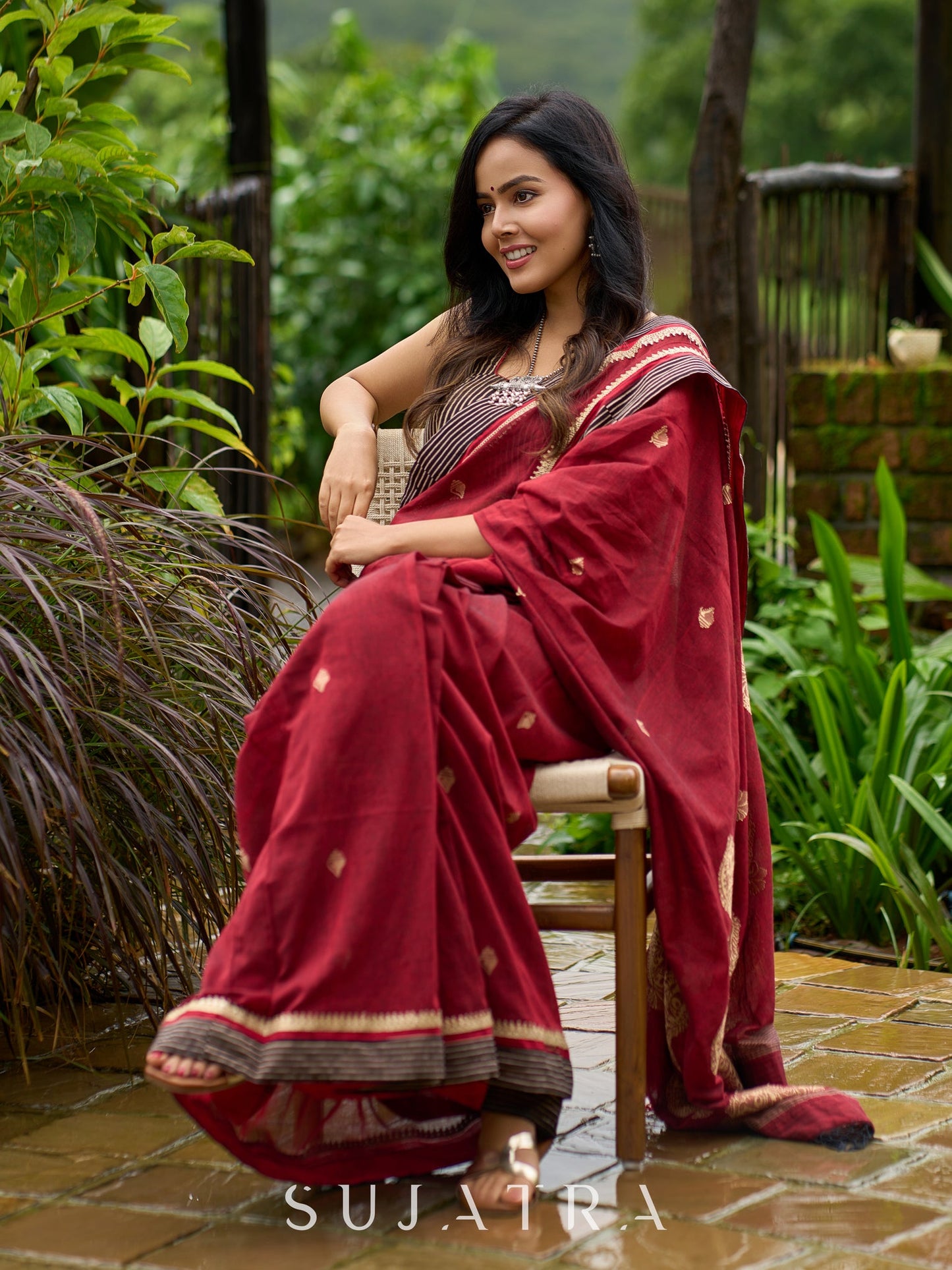 Artisanal maroon Jamdani saree elevated with zari-bordered detailing