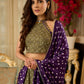 Vibrant Mehendi green and purple bandhani lehenga paired with a mirror work halter neck choli and matching dupatta.