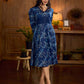 Indigo printed dress featuring dragonfly motifs, gathered sleeves with cuffs, and navy blue pleated waist detailing accented with pearls, creating a graceful silhouette with refined artisanal charm.