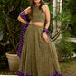 Vibrant Mehendi green and purple bandhani lehenga paired with a mirror work halter neck choli and matching dupatta.