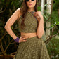 Vibrant Mehendi green and purple bandhani lehenga paired with a mirror work halter neck choli and matching dupatta.