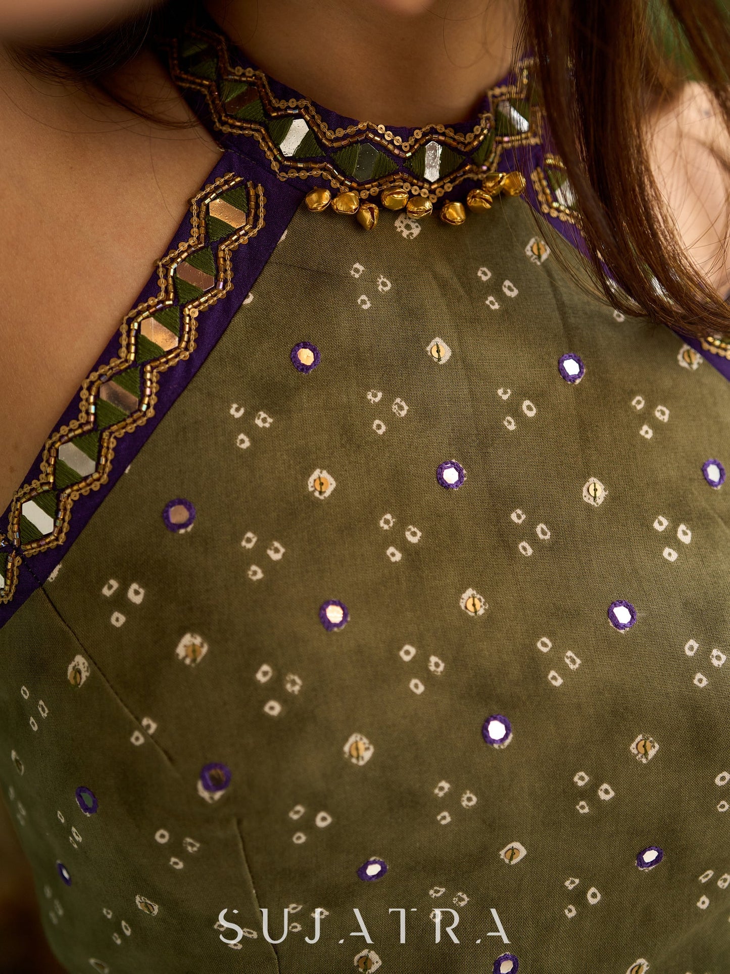 Vibrant Mehendi green and purple bandhani lehenga paired with a mirror work halter neck choli and matching dupatta.