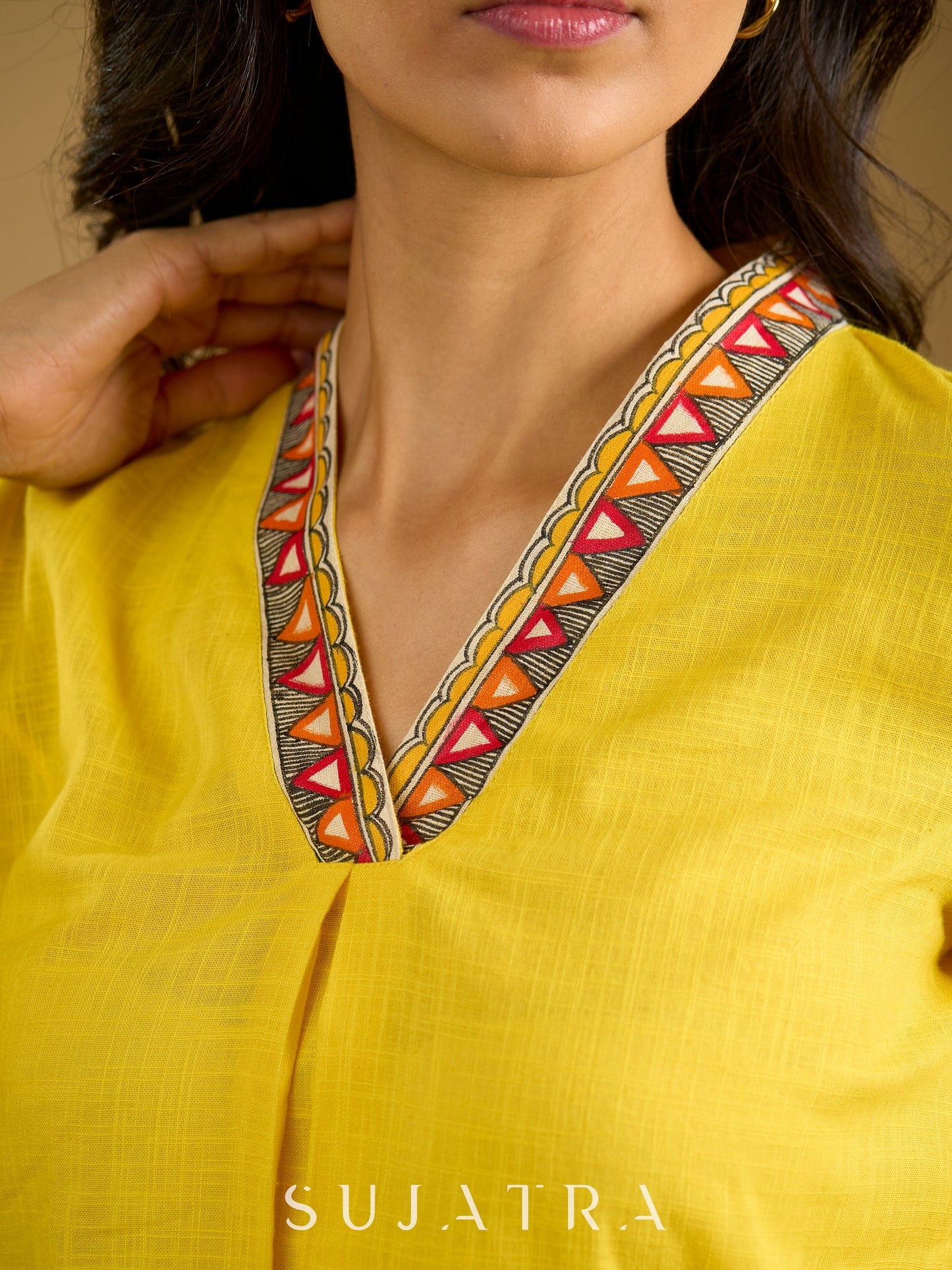 Traditional madhubani hand painting enhances this bright yellow cotton top.