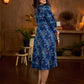 Indigo printed dress featuring dragonfly motifs, gathered sleeves with cuffs, and navy blue pleated waist detailing accented with pearls, creating a graceful silhouette with refined artisanal charm.