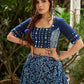 Modern folkloric layered indigo lehenga beautifully contrasted with a luminous full mirror work choli - Lehriya dupatta optional.
