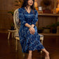 Indigo printed dress featuring dragonfly motifs, gathered sleeves with cuffs, and navy blue pleated waist detailing accented with pearls, creating a graceful silhouette with refined artisanal charm.