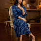 Indigo printed dress featuring dragonfly motifs, gathered sleeves with cuffs, and navy blue pleated waist detailing accented with pearls, creating a graceful silhouette with refined artisanal charm.