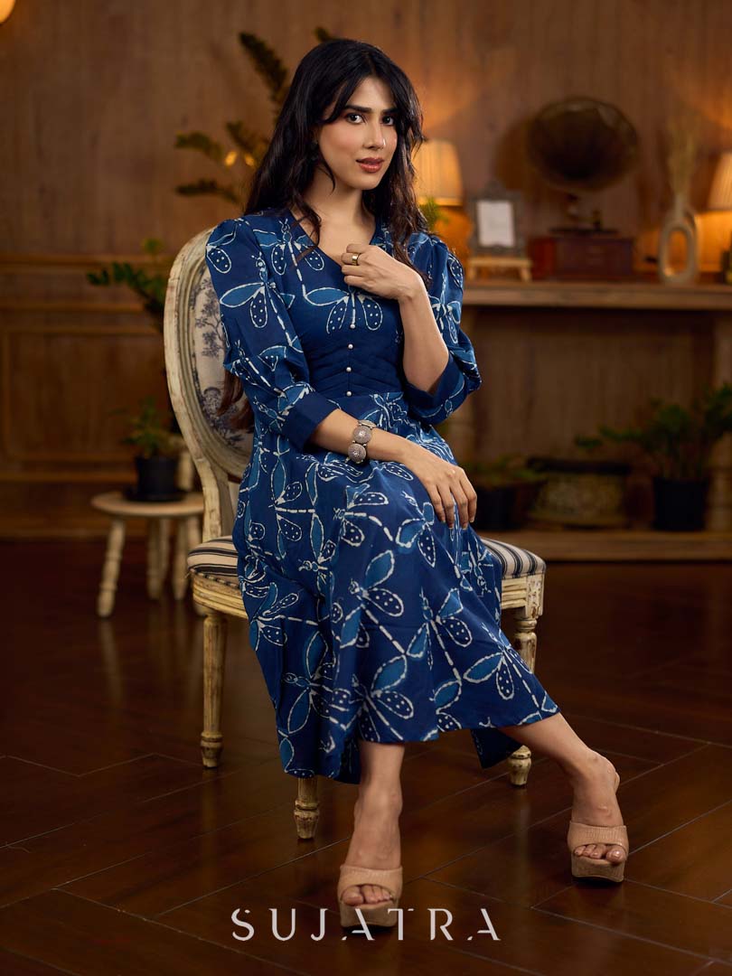 Indigo printed dress featuring dragonfly motifs, gathered sleeves with cuffs, and navy blue pleated waist detailing accented with pearls, creating a graceful silhouette with refined artisanal charm.
