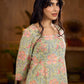 Soft green Gulmohar-printed dress featuring a square neckline and pearl-highlighted motifs, finished with an elasticated waist to create a flattering cinched silhouette with effortless charm.