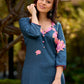 Graceful teal kurta with delicate pink lotus printing, subtle pink accents, and a statement patch above the neckline.