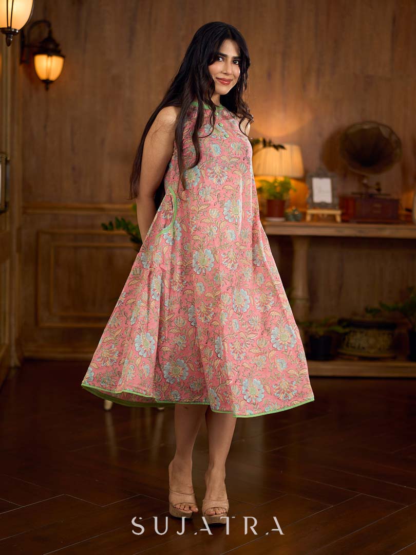 Soft peachy pink floral halter-neck dress with fresh green accents, crafted in a bias-cut silhouette that creates graceful flow and a fluid drape for an effortless summer look.