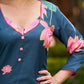 Graceful teal kurta with delicate pink lotus printing, subtle pink accents, and a statement patch above the neckline.