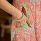 Soft peachy pink floral halter-neck dress with fresh green accents, crafted in a bias-cut silhouette that creates graceful flow and a fluid drape for an effortless summer look.